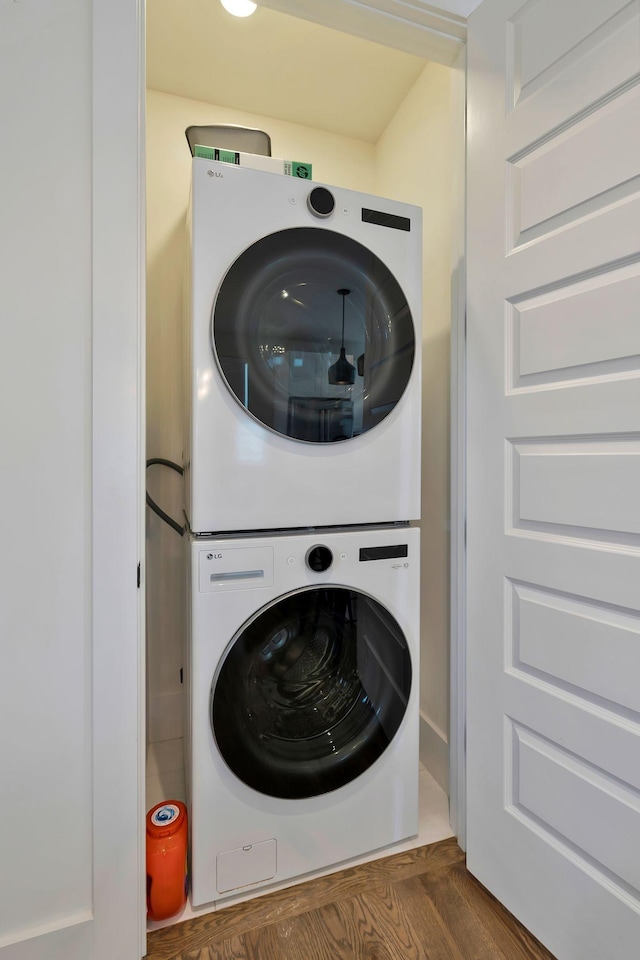 washroom featuring stacked washer / dryer and laundry area
