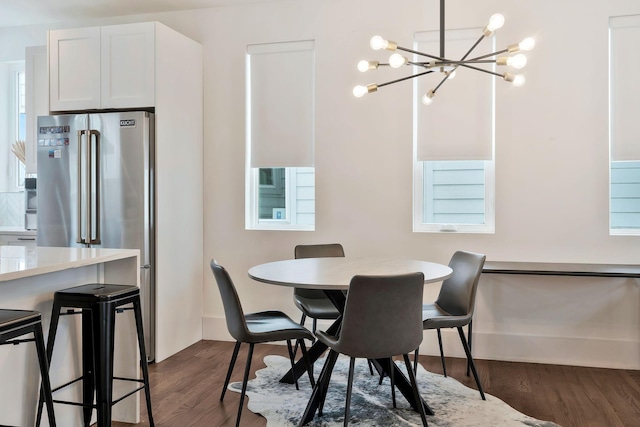dining area featuring dark wood-style floors and a notable chandelier