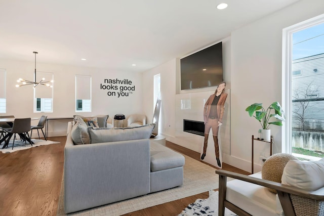 living area featuring plenty of natural light, a chandelier, and wood finished floors
