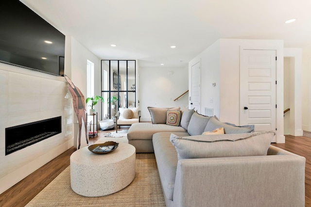 living area with visible vents, wood finished floors, a fireplace, and recessed lighting