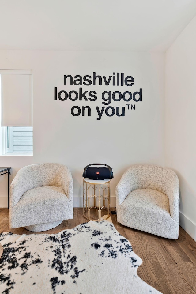 living area featuring baseboards and wood finished floors