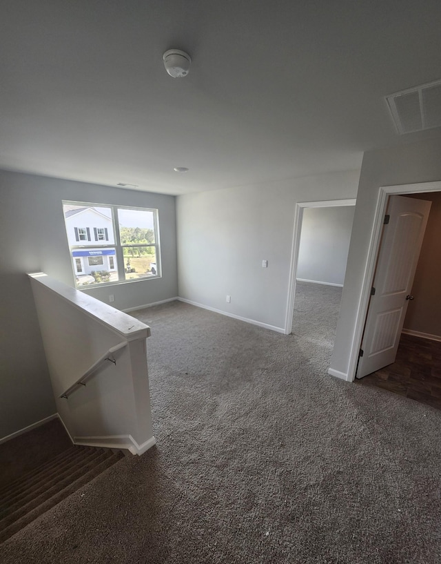 empty room featuring carpet, baseboards, and visible vents