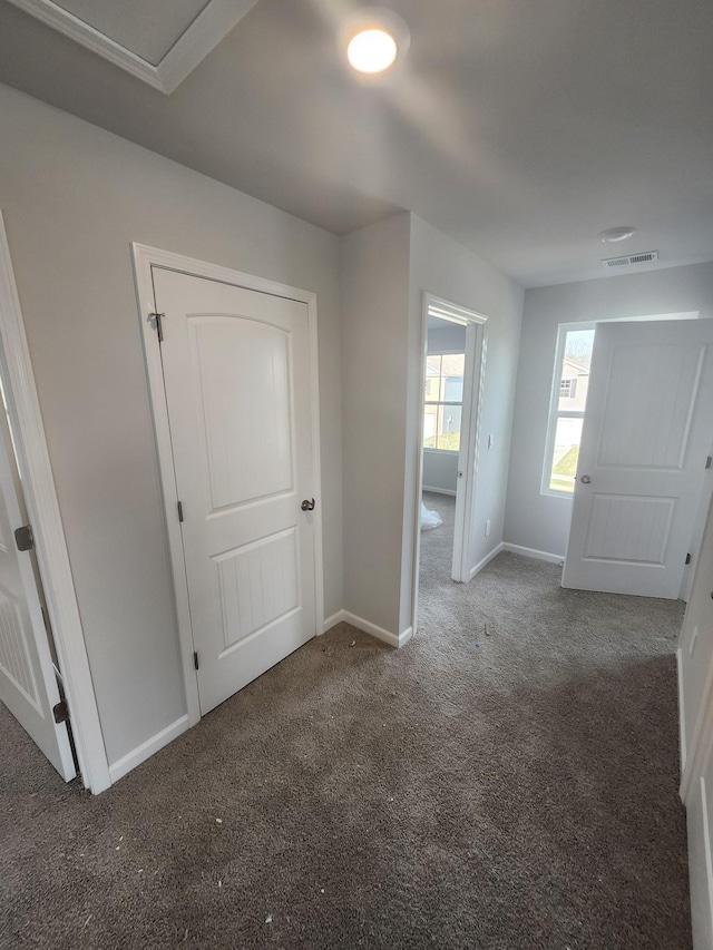 carpeted empty room featuring baseboards and visible vents