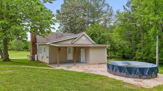 455 No Pone Valley Rd NW, Georgetown, TN 37336 - rear view of house featuring a lawn, a chimney, an outdoor pool, a patio area, and a shingled roof