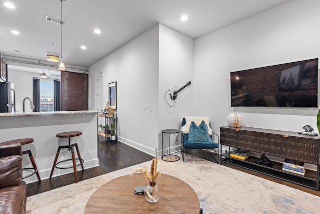 living room with visible vents, baseboards, dark wood-type flooring, and recessed lighting
