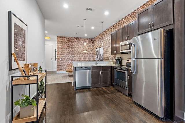 kitchen with a sink, stainless steel appliances, dark brown cabinetry, visible vents, and dark wood-style floors