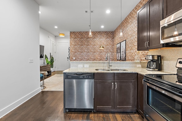 kitchen with a peninsula, dark brown cabinets, a sink, visible vents, and appliances with stainless steel finishes