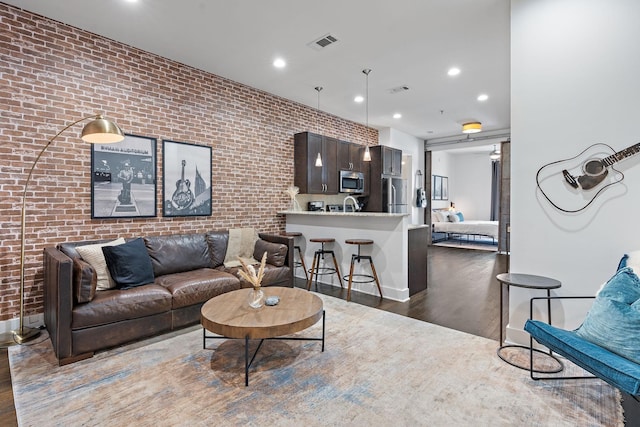living area featuring baseboards, dark wood-type flooring, visible vents, and recessed lighting