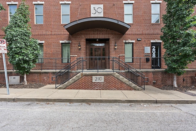 entrance to property featuring brick siding