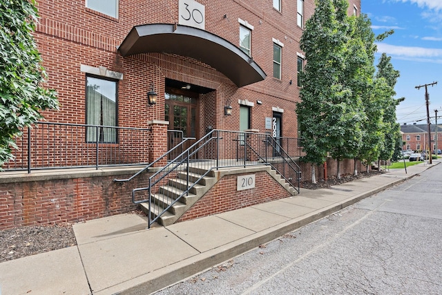 view of exterior entry featuring brick siding