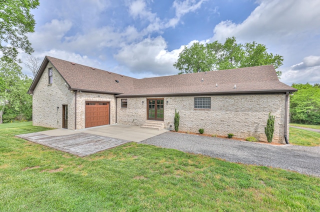 ranch-style home featuring a front lawn, driveway, a shingled roof, and a garage