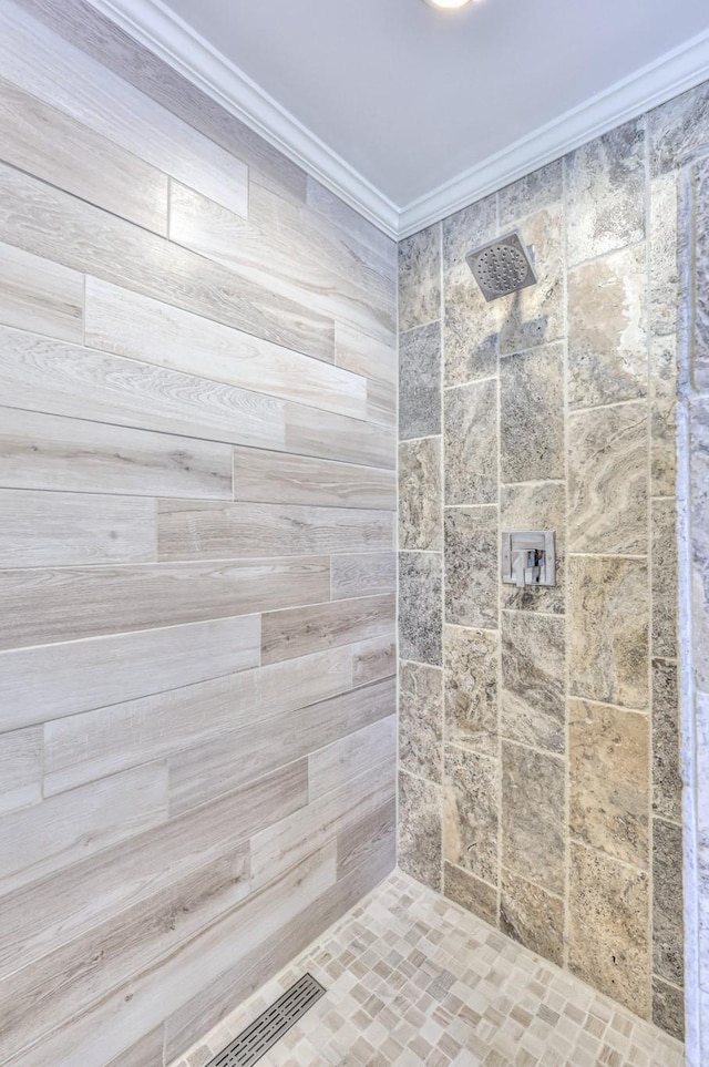 full bathroom featuring tiled shower and ornamental molding