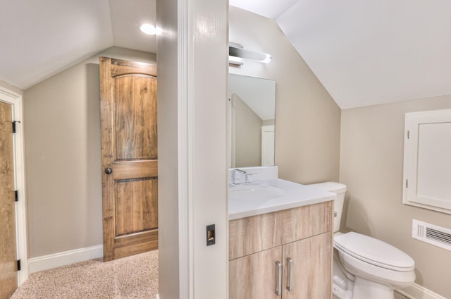 bathroom with vanity, toilet, baseboards, and lofted ceiling