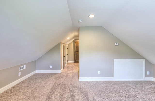 additional living space featuring vaulted ceiling, carpet, visible vents, and baseboards