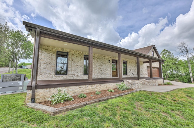 view of front of house featuring covered porch, brick siding, and a front lawn