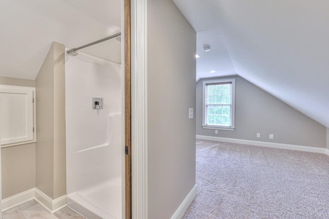 full bathroom with baseboards, lofted ceiling, and a shower stall