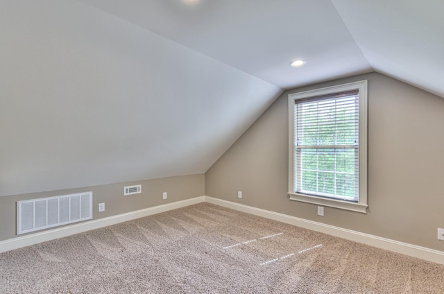 bonus room featuring baseboards, carpet flooring, visible vents, and vaulted ceiling