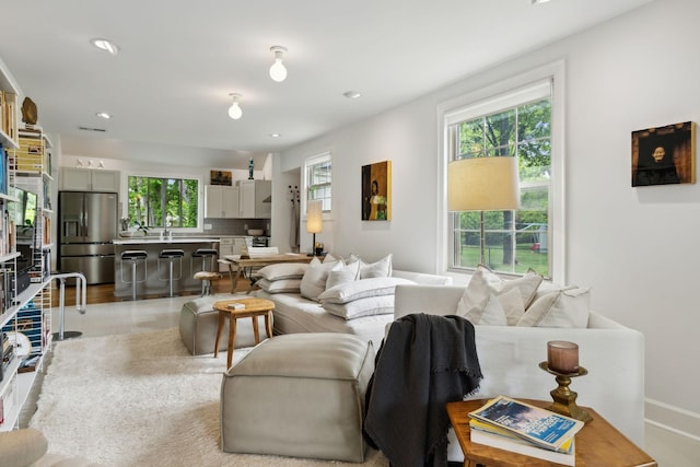 living area featuring baseboards and recessed lighting