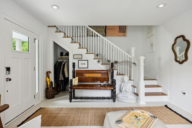 foyer entrance with stairs, baseboards, and recessed lighting