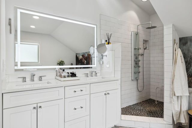 full bathroom with double vanity, a walk in shower, lofted ceiling, and a sink