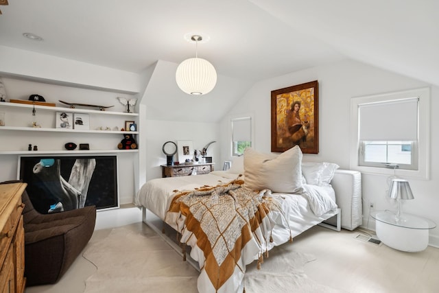 bedroom featuring vaulted ceiling, visible vents, and multiple windows