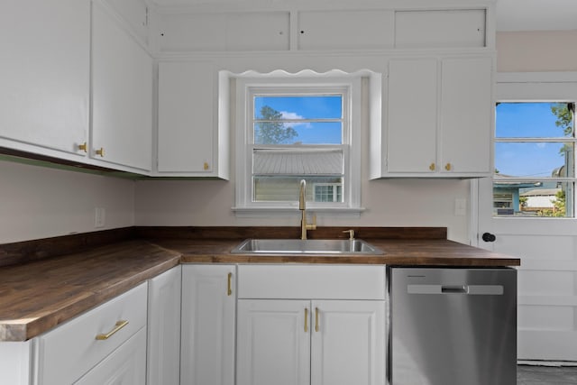 kitchen featuring white cabinets, plenty of natural light, stainless steel dishwasher, and a sink