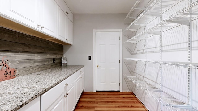 clothes washing area with light wood-type flooring