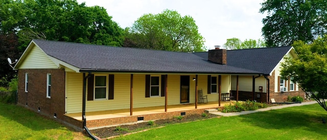 rear view of house with a porch, a yard, a chimney, and crawl space
