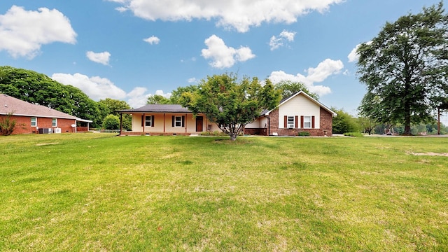 back of property with a yard, brick siding, and a porch