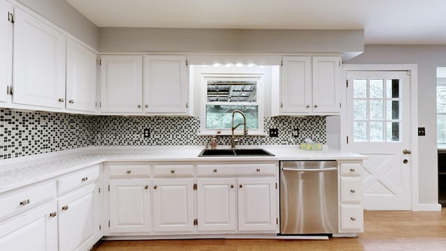 kitchen with white cabinetry, light countertops, a sink, and dishwasher