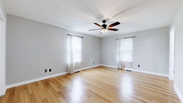 unfurnished room featuring plenty of natural light, baseboards, a ceiling fan, and light wood-type flooring
