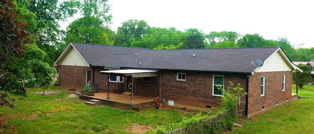 back of house with a yard, a patio, brick siding, and crawl space