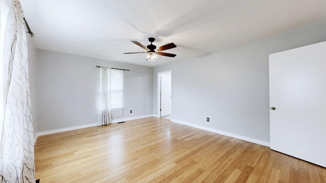 unfurnished room with ceiling fan, baseboards, visible vents, and wood finished floors