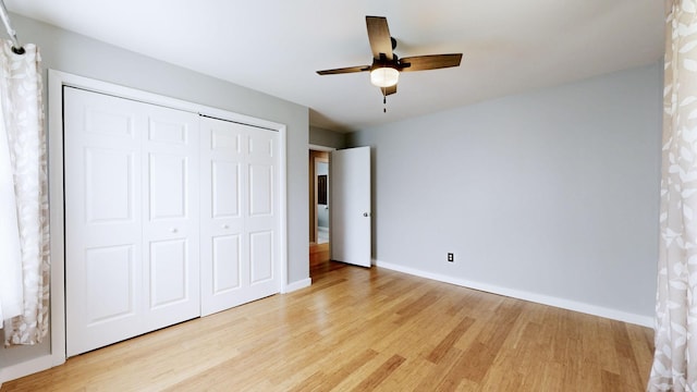 unfurnished bedroom with baseboards, a closet, and light wood-type flooring