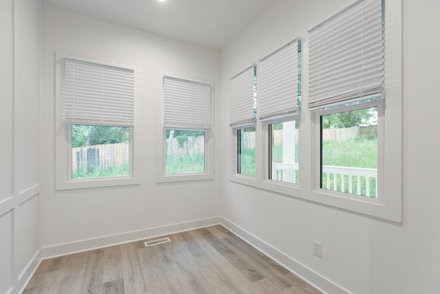 unfurnished room featuring light wood-style flooring, baseboards, and visible vents