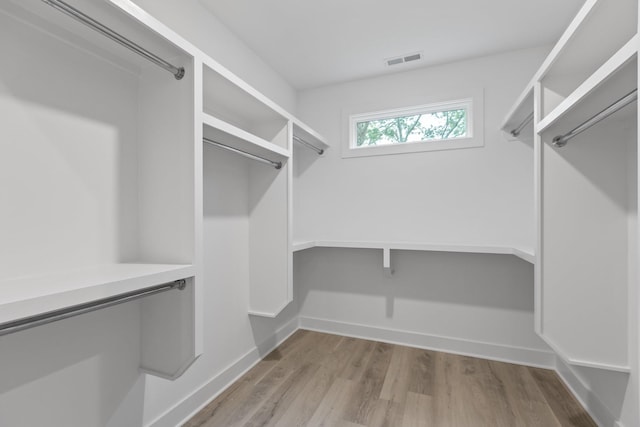 spacious closet featuring visible vents and wood finished floors