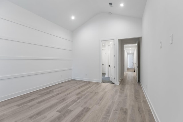 spare room with baseboards, recessed lighting, light wood-style flooring, and high vaulted ceiling