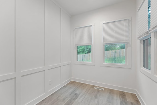 empty room featuring baseboards, visible vents, and light wood-style floors
