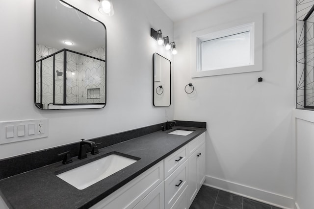 bathroom featuring double vanity, baseboards, a stall shower, and a sink