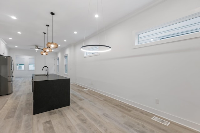 kitchen with a sink, freestanding refrigerator, visible vents, baseboards, and recessed lighting