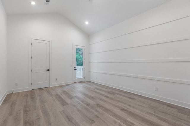 spare room featuring recessed lighting, wood finished floors, baseboards, and high vaulted ceiling