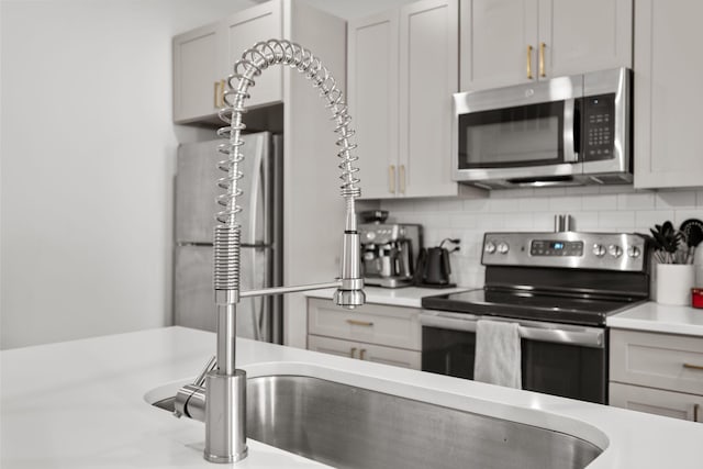 1677 54th Ave N Unit 318, Nashville, TN 37209 - kitchen with appliances with stainless steel finishes, light countertops, and decorative backsplash