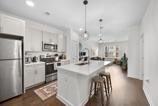 1677 54th Ave N Unit 318, Nashville, TN 37209 - kitchen featuring appliances with stainless steel finishes, a sink, decorative backsplash, open floor plan, and a kitchen island with sink
