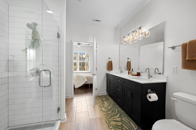 1677 54th Ave N Unit 318, Nashville, TN 37209 - bathroom with double vanity, connected bathroom, a stall shower, toilet, and a ceiling fan