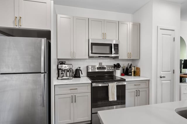 1677 54th Ave N Unit 318, Nashville, TN 37209 - kitchen featuring appliances with stainless steel finishes, light countertops, backsplash, and gray cabinets