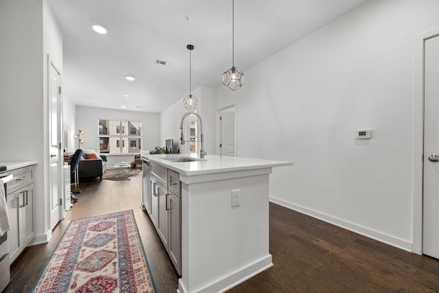 1677 54th Ave N Unit 318, Nashville, TN 37209 - kitchen with a sink, dark wood-type flooring, a center island with sink, light countertops, and pendant lighting