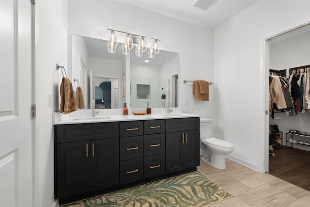 1677 54th Ave N Unit 318, Nashville, TN 37209 - bathroom with double vanity, a stall shower, wood finished floors, and a spacious closet