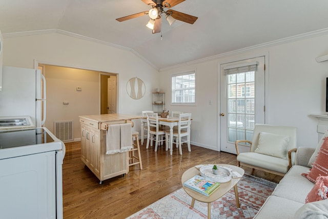 living area featuring wood finished floors, visible vents, ceiling fan, lofted ceiling, and ornamental molding