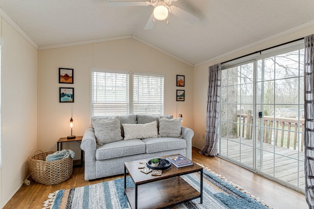 living room featuring a wealth of natural light, ceiling fan, vaulted ceiling, and wood finished floors
