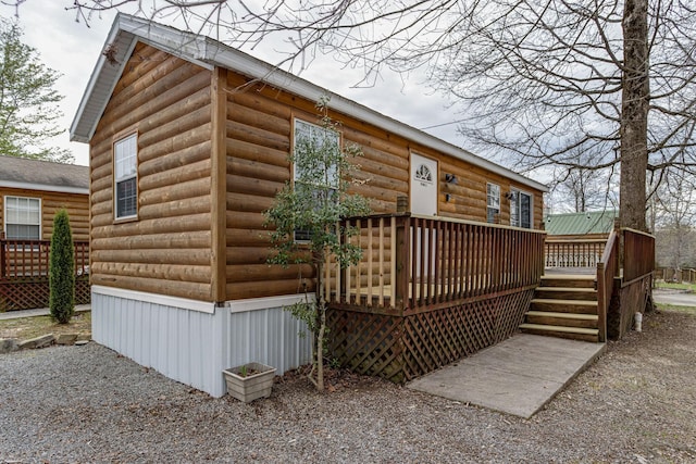 exterior space with a deck and log veneer siding